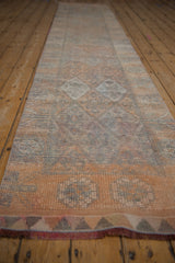 Distressed Kurd runner pile showing geometric blossoms, even wear, and secured side edge.