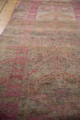 Close-up of distressed vintage Kurd runner pile, highlighting fuchsia geometric and floral patterns.