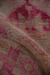 Textured hand-knotted pile of a distressed Kurd runner with fuchsia geometric guls.