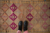 Distressed Kurd runner with geometric fuchsia, orange, and muted beige blossoms, showing abrashes.