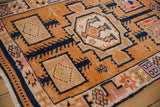 Distressed vintage Kurd runner with geometric tangerine, navy, and ivory germinating vine patterns.