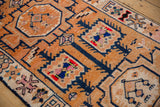 Softened pile of a distressed Kurd runner, showing geometric vines in tangerine, navy, and colorful accents.