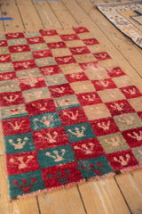Angled view of a vintage Tulu rug highlighting its distressed checkered pattern.