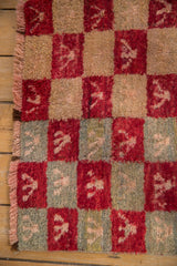 Intact side cord selvage and shaggy, checkered pile of a vintage Turkish Tulu rug.