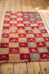 Low angle view highlighting the plush, shaggy pile of a vintage checkered Tulu rug.