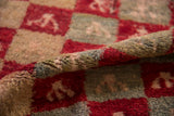 A folded vintage Tulu rug highlights the plush, shaggy pile and distressed checkered pattern.
