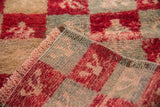 Hand-knotted foundation and secured side cord of a vintage distressed Tulu rug.