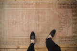 Overhead view showing the prayer design and worn texture of a distressed vintage Oushak rug.