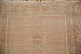 Evenly worn, low pile texture on the fringed end of a distressed vintage Oushak rug.