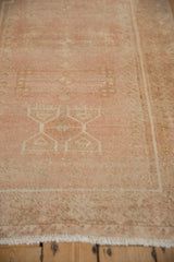 The even wear and distressed texture of a vintage Oushak rug in dusty blush and coffee brown.