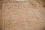 Angled view showing the evenly worn, low pile of a distressed vintage Oushak prayer rug.