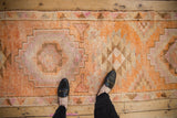 Distressed vintage Kurd runner with textured pile and geometric designs in tangerine, ivory, magenta.