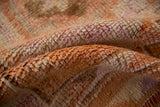 Distressed Kurd rug pile with short height, showing tangerine, ivory, and magenta tones.