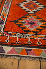Vintage Kurd runner's textured pile, showing geometric serrated diamond motifs in rust, charcoal, and blush.