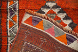 Hand-knotted Kurd rug foundation with geometric pile detail in rust, tangerine, and aubergine.