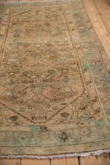Distressed Hamadan rug pile, showing faint foundation through beige and mint Herati motifs.