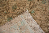Distressed Hamadan rug pile close-up, showing worn texture, beige foundation, and mint accents.