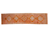 Distressed Vintage Kurd runner rug, single column geometric medallions in rust, tangerine, and pale raspberry.