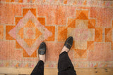 Distressed Kurd runner with geometric stepped patterns, worn pile in pale raspberry, tangerine.
