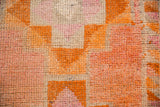 Distressed Kurd rug runner detail, hand-knotted pile with geometric blocks in raspberry and tangerine orange.
