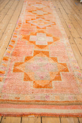 Distressed vintage Kurd runner with orange fringe, flat weave, and geometric pattern detail.