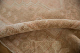 Detail of the distressed Oushak rug's soft, low pile showing even wear to the knot heads.