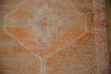 Heavily abrashed distressed Kurd rug runner pile with pale rust and faded magenta tones.