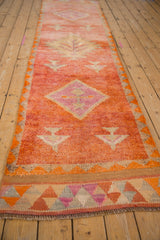 Geometric border with tangerine, pink, and pale aubergine triangles on distressed Kurd runner's end.