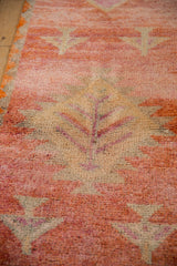Distressed Kurd rug, germinating plant motif, textured pile, raspberry, rust, ivory.