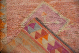 Distressed Kurd runner, showing textured pile in soft raspberry, tangerine, and ivory with woven back.