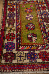 Hand-knotted Oushak: textural detail of moss green abrash field and vibrant wide banded floral border.