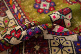 Textured pile of vintage Turkish Oushak rug showcasing vibrant moss green, deep violet, red, and pink patterns.