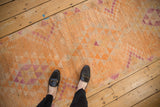 Distressed vintage Kurd runner with faded orange, purple geometric motifs and worn pile.