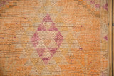 Distressed Kurd rug detail: soft violet serrated medallion, pale tangerine and rust pile.