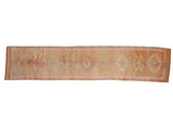 Distressed Kurd runner rug, geometric medallions in cantaloupe, faded magenta, and ivory.