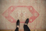 Vintage distressed Oushak runner, dusty raspberry stepped medallion and ivory trefoil motifs.
