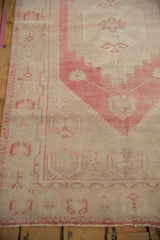 Distressed Oushak runner close-up showing dusty raspberry trefoil florals and boteh border.