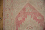 Distressed pile of vintage Oushak runner in time-softened dusty raspberry and ivory.