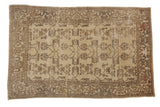 Distressed vintage Oushak rug, dusty cream field, rose and silver floral vines, cloud-band border.