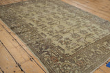 Corner of distressed Oushak rug, featuring cloud-band border and dusty rose, silver floral vines.