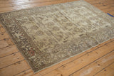 Close-up of vintage distressed Oushak rug corner, showing time-softened pile and cloud-band border.