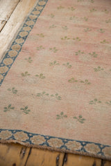 Distressed vintage Turkish Sparta carpet, pink field, green clover motifs, floral blue border, worn texture.