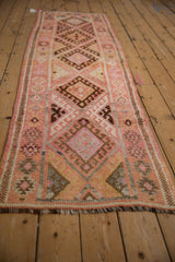 Detail of hand-knotted Kurd runner: hook-and-latch diamond, serrated leaves, abrashes, blush, and brown.