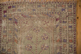 Distressed Oushak rug runner corner with worn pile, displaying muted terracotta, mauve, beige geometrics, fringe.
