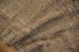 Distressed Oushak rug close-up with worn pile, faint foundation, and mauve-beige blossoms.