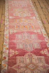 Distressed dusty cochineal field with geometric quatrefoil medallion and patterned selvage.