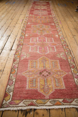 Distressed Kurd runner's geometric quatrefoil medallion, intricate border, and ivory fringe.