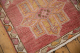 Distressed Kurd rug corner, showing geometric border and field in cochineal, ivory, tangerine.