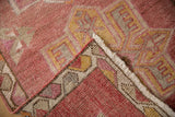 Distressed Kurd rug corner folded, revealing short pile, cochineal-saffron patterns, intact selvage.