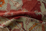 Distressed cherry red and platinum pile with geometric leaf motifs on the vintage Oushak rug.